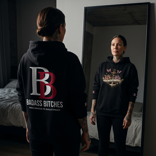Women wearing a Healing But Make It Ruthless black hoodie with 'Badass Bitches' logo, standing in front of a mirror.