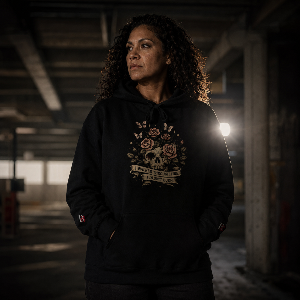 Black oversized hoodie with skull, rose, and butterfly graphic featuring the quote "I WALKED THROUGH FIRE, I DIDN'T BURN