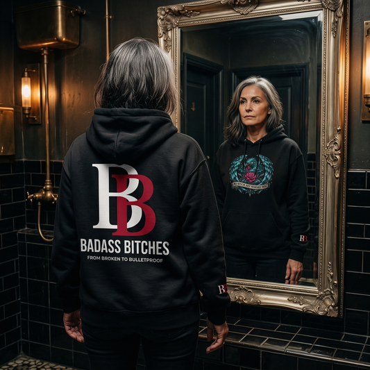 Women wearing a No Rescue Just Resurrection black hoodie with 'Badass Bitches' logo, standing in front of a mirror.