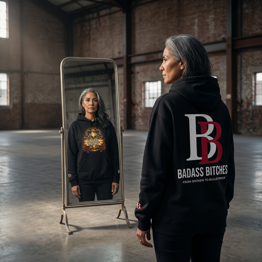 Women wearing a Not Too Old, Not Too Broken, Not Too Late black hoodie with a Badass Bitches logo, standing in an industrial setting.