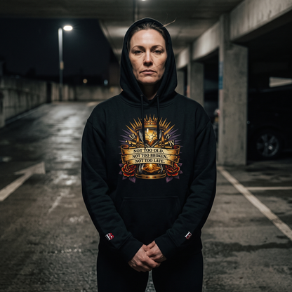 Women wearing a Not Too Old, Not Too Broken, Not Too Late black hoodie with a graphic design in an underground parking lot