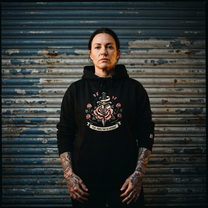 Women wearing a PTSD: People That See Different black hoodie with a graphic design in front of a rusty metal shutter.