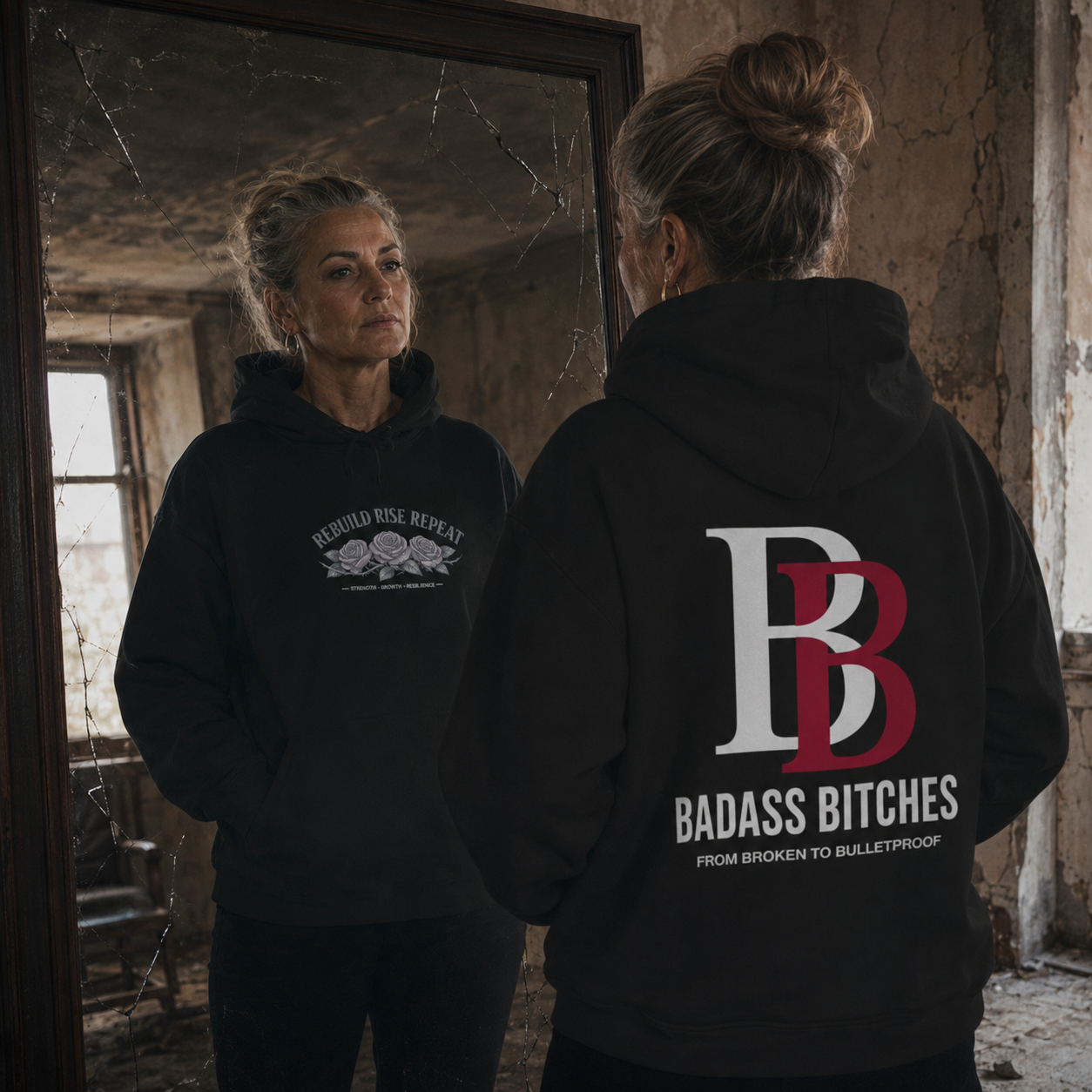 Women wearing a "Rebuild Rise Repeat" black hoodie with a logo and text, standing in a dilapidated room.