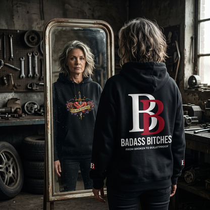 Women wearing a Scars Are My Signature  hoodie with 'Badass Bitches' text in a workshop setting