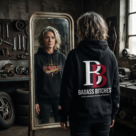 Women wearing a Scars Are My Signature  hoodie with 'Badass Bitches' text in a workshop setting