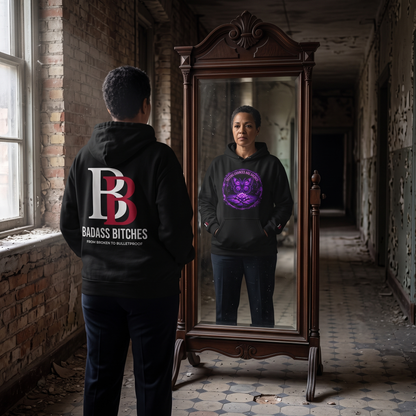 Women wearing a Second Chances Are Sacred hoodie with 'Badass Bitches' logo, standing in an abandoned building with a large mirror.