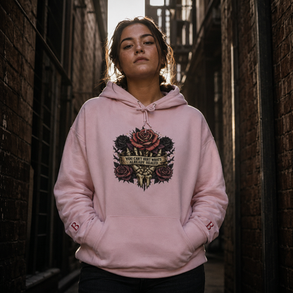 Person wearing a pink hoodie with "You can't hurt whats already healed" graphic design in an urban setting
